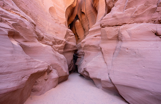 View along a hike inside the deep and narrow Antelope Canyon. This slot canyon is located near the city of Page in Arizona, USA. The walls are shaped like waves.