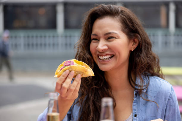 szczęśliwa kobieta jedząca tacos w ulicznej restauracji z jedzeniem - restauracja meksykańska zdjęcia i obrazy z banku zdjęć