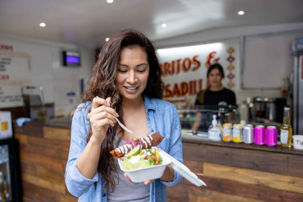 istock Woman eating enchiladas at a small Mexican restaurant 1405734631