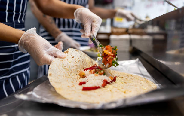 멕시코 레스토랑에서 퀘사 딜라를 준비하는 웨이트리스에 클로즈업 - burrito 뉴스 사진 이미지