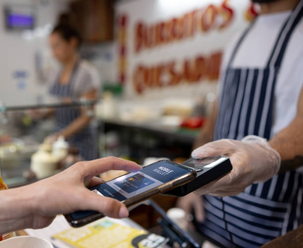 istock Customer making a contactless payment with her phone at a restaurant 1405734659