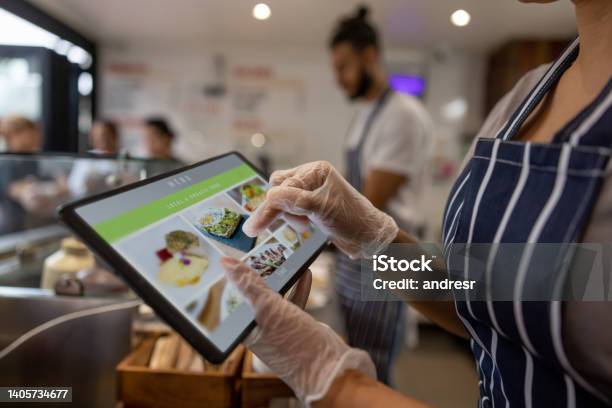 Closeup On A Waitress Using A Tablet To Take An Order At A Restaurant Stock Photo - Download Image Now