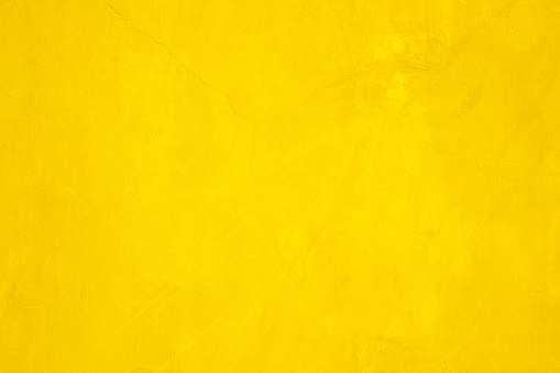 Concrete wall yellow color for texture background. Abstract grunge bright colorful color background with growing effect. Pastel yellow colored low contrast textured with roughness and irregularities.