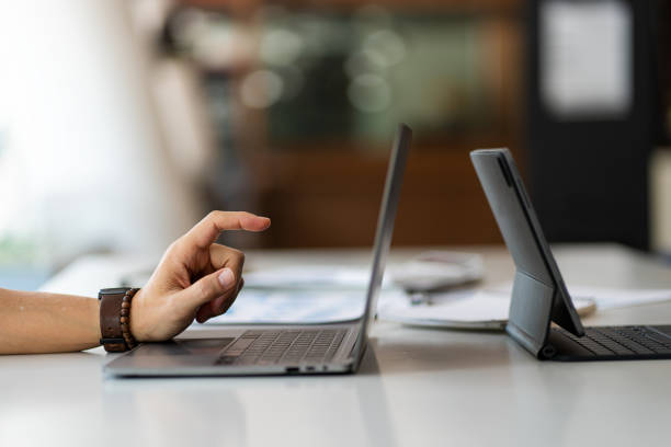 istock Close-up of businessman using blank screen digital tablet at desk while searching for business information in the modern workplace 1405735702