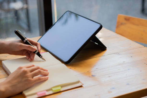 istock Close-up of businessman using blank screen digital tablet at desk while searching for business information in the modern workplace 1405735800