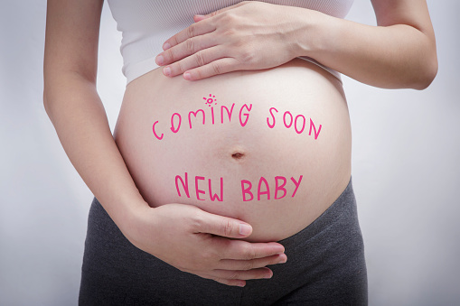 Pregnancy writing the word coming soon new baby on stomach, pregnancy and newborn baby