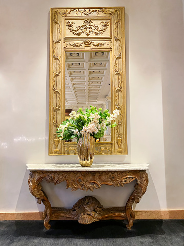 Luxury interior detail with golden mirror and console table