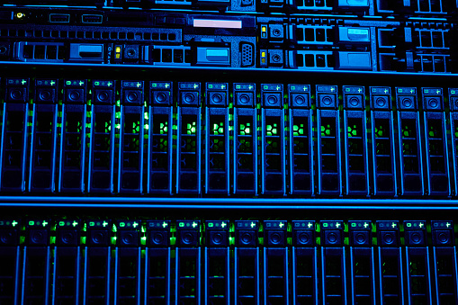 Graphic background image of blade servers in blue neon light stacked in data center, copy space