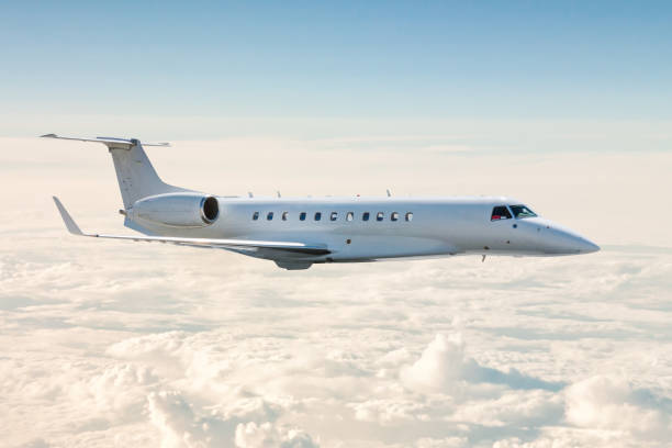 el jet de negocios blanco vuela en el aire sobre las nubes - jet corporativo fotografías e imágenes de stock