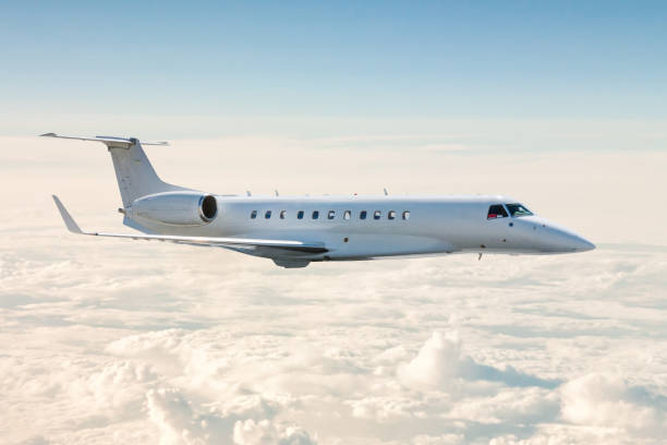 l’avion d’affaires blanc vole dans les airs au-dessus des nuages - jet photos et images de collection