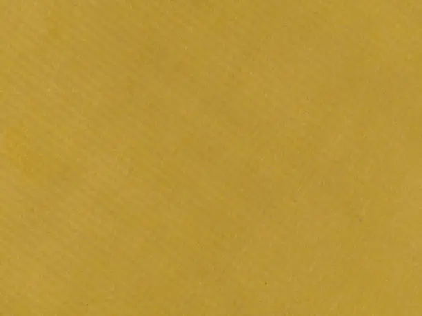 Mustard gradient paper background with textured striped surface. Yellow-mustard sheet of paper with a shadow pattern