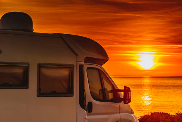 istock Camper vehicle on beach at sunrise 1405754775