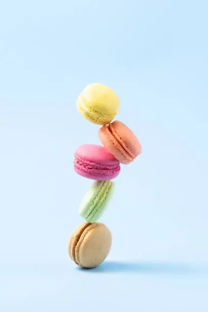 Photo of Confectionery, macaroons balance over blue background