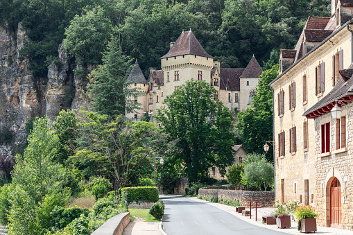 Roque-Gageac - France. July 01, 2021: Castle of La Malartrie overlooks one of most beautiful village of France, La Roque Gageac, Perigord Noir,  Dordogne valley