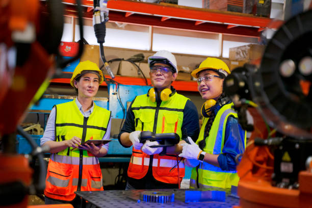 istock Employees are working at factory with robotic arms. 1405758886