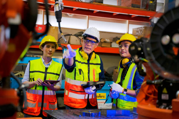 istock Employees are working at factory with robotic arms. 1405758887