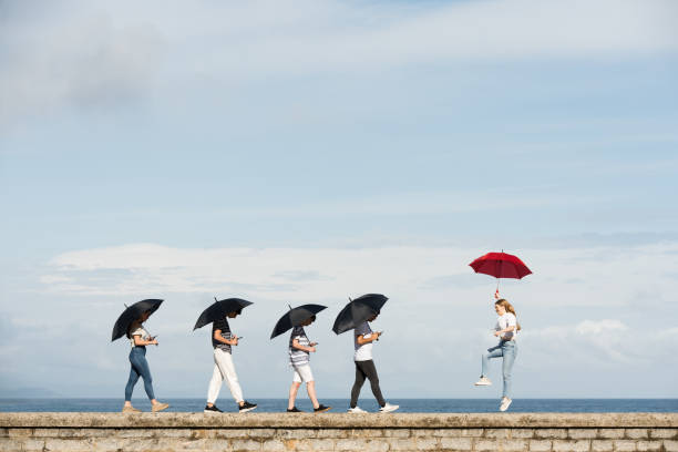 mondo digitale e concetto di mondo reale - standing out from the crowd individuality umbrella contrasts foto e immagini stock