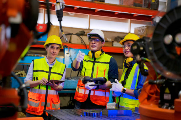 istock Employees are working at factory with robotic arms. 1405758894