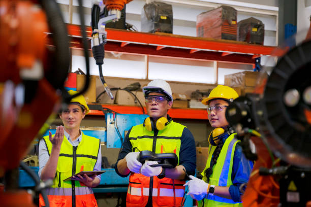 istock Employees are working at factory with robotic arms. 1405758909
