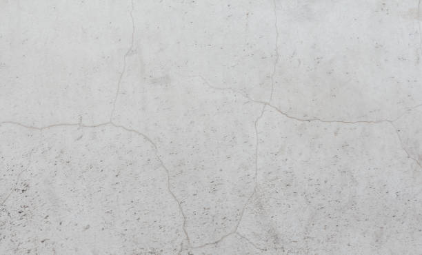 istock White weathered wall background with cracks and splashes. An old concrete wall with beautiful grunge texture. 1405759832