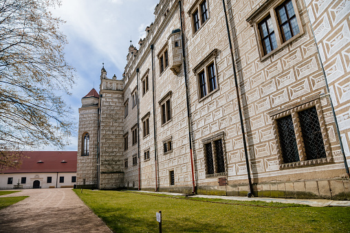 Litomysl, Czech Republic, 17 April 2022: Renaissance castle, UNESCO World Heritage Site, chateau with sgraffito mural decorated plaster at facade at sunny day, medieval historical town with park