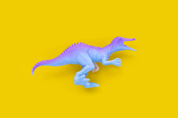 istock Plastic dinosaur toys on yellow background. 1405765159