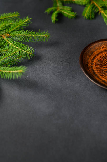 istock Gray Background with Live Christmas Tree Branches and Brown-orange Clay Plate. Christmas Theme 1405767012