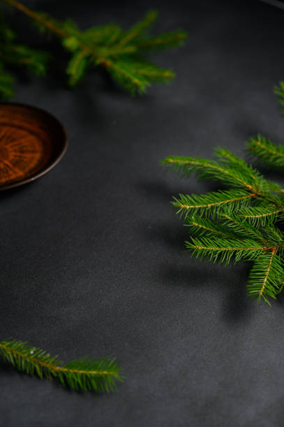 istock Vertical screensaver with a Clay Plate and Green Christmas tree branches on a dark gray Background 1405768646