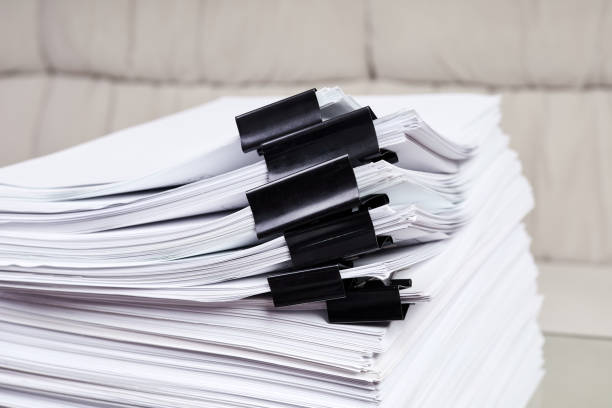 istock A stack of office papers, some of which are fastened with black binders 1405769961