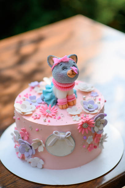 Festive pink cake with a cat on top. stock photo