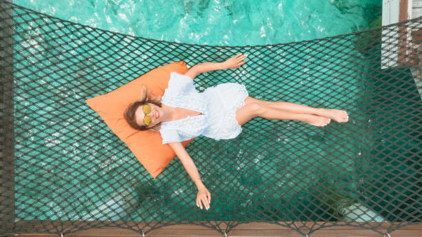 Beautiful woman lying on hammock over ocean in Maldives stock photo