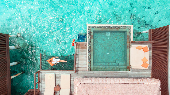 Beautiful woman lying on hammock over ocean in Maldives