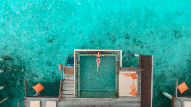 istock Beautiful woman enjoying swimming pool on ocean side 1405771849