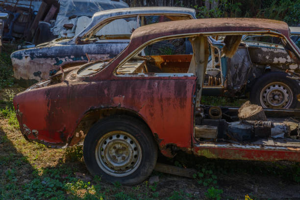 Old cars rolled for scrapping in a meadow. Alsace, France.