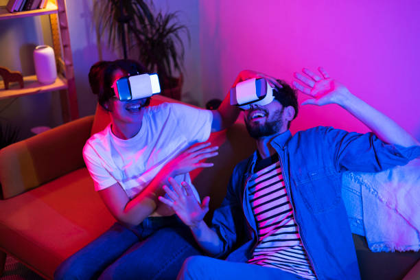 istock Young couple having fun at home and playing with virtual reality headsets 1405776532