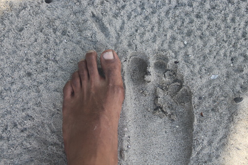left foot and right foot footprint on the sand