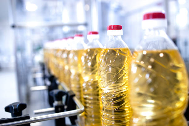 Vegetable oil production and bottles filled with sunflower oil being transported on conveyor machine. stock photo