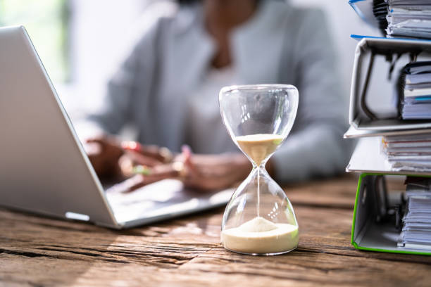 Black Accountant Woman Working With Invoice Black Accountant Woman Working With Invoice And Hourglass checking the time stock pictures, royalty-free photos & images