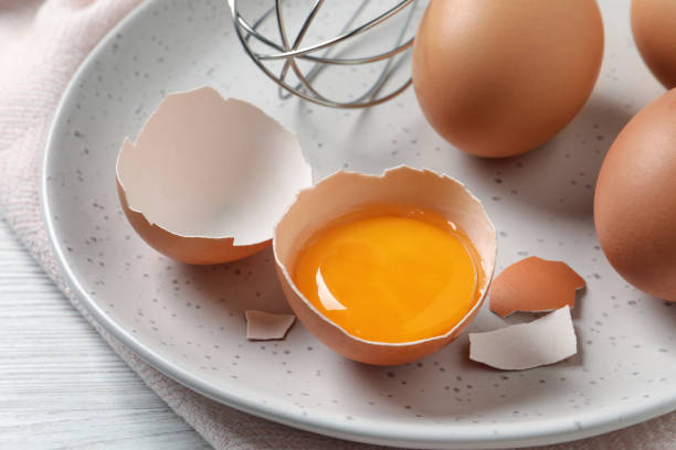 istock Whole and cracked chicken eggs on white wooden table, closeup 1405781145
