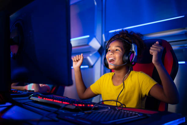 かわいい若い女の子は幸せを感じ、コンピュータのビデオゲームに勝つために興奮しています。 - surfing the net ストックフォトと画像