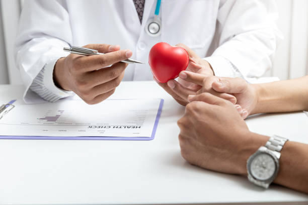 Doctor heart and patient. Physician explaining health exam to patient. stock photo