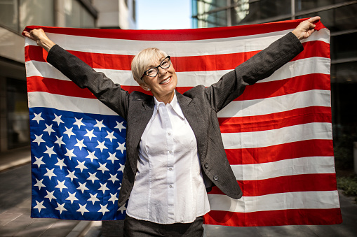 Mature businesswoman posing with American flag