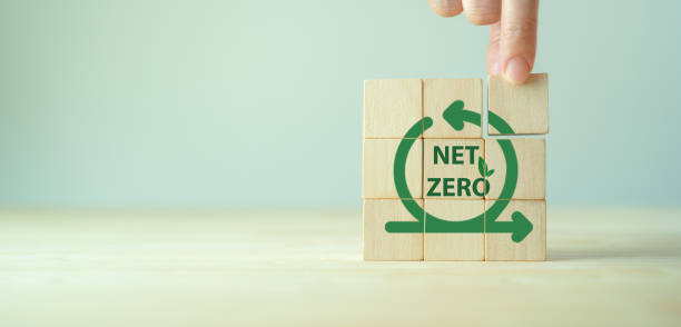 istock Net zero, zero emissions. Carbon neutral. Greenhouse gas emissions target. Climate neutral long term strategy. Sustainability. Holding wooden cubes with net zero emissions icon on grey background. 1405787025