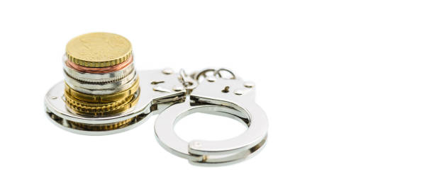 Business fraud and tax avoidance / tax evasion concept : Coin in a small silver handcuff, depicts the use of illegal methods to modify financial situation or reports to lower or avoid paying tax. Business fraud and tax avoidance / tax evasion concept : Coin in a small silver handcuff, depicts the use of illegal methods to modify financial situation or reports to lower or avoid paying tax. ponzi scheme stock pictures, royalty-free photos & images