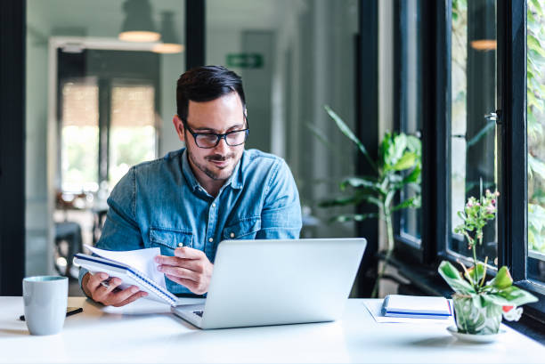istock Confident businessman analyzing strategy while working on laptop at home office 1405788799
