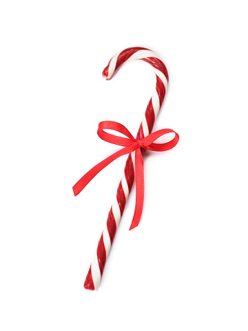 Delicious Christmas candy cane with red bow isolated on white, top view