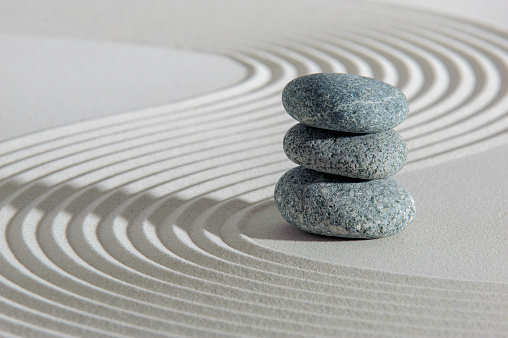 Vertical shoot of balanced pebbles on beach sand