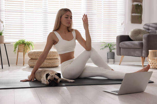 mulher bonita com cachorro após aula online de yoga em casa - pose of sage marichi - fotografias e filmes do acervo