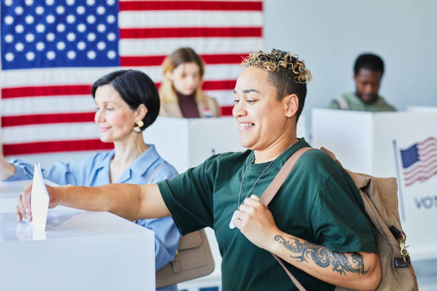 votantes que ponen boletas en la papelera - women ethnic american culture flag fotografías e imágenes de stock