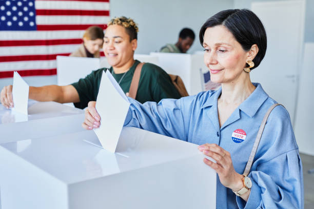 istock Female Voters Putting Ballots in Bin 1405791674